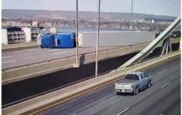 On Burlington Skyway, strong winds roll over transport truck