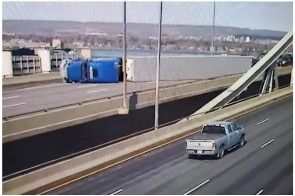 On Burlington Skyway, strong winds roll over transport truck